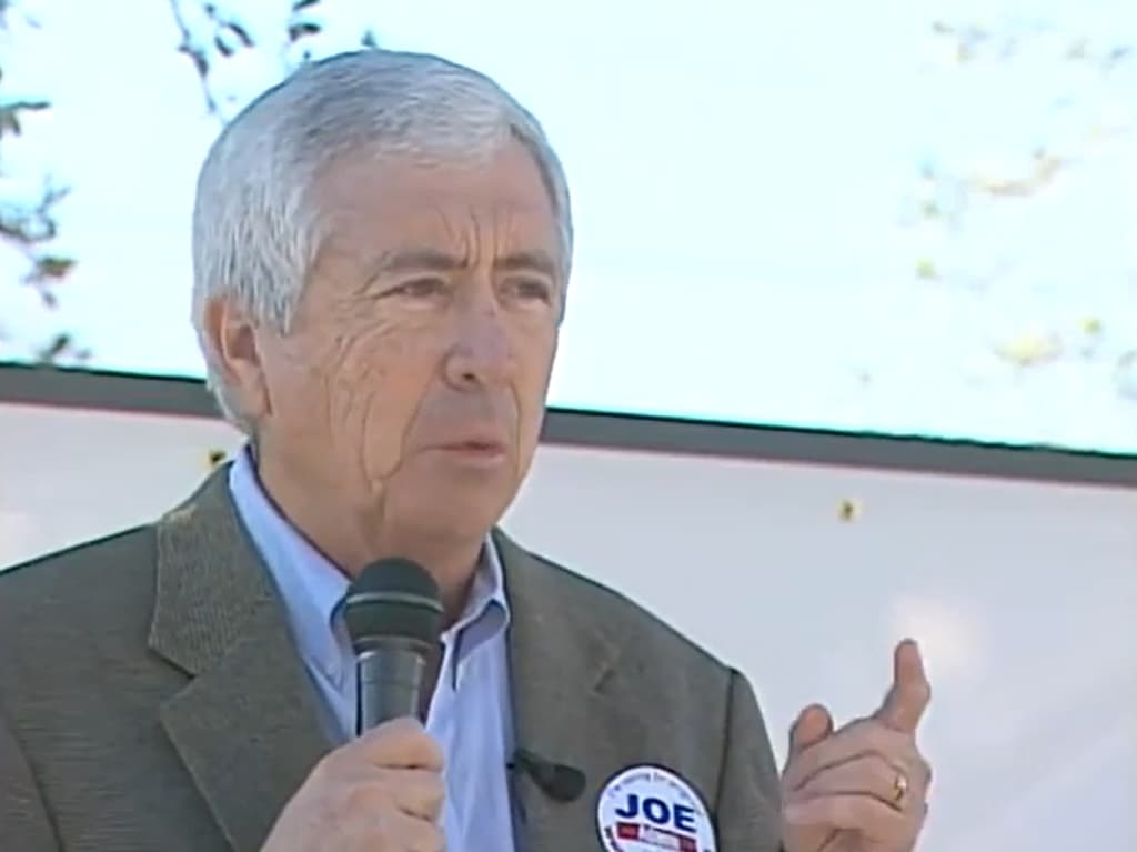 Joe Adame speaking at an outdoor event with a microphone