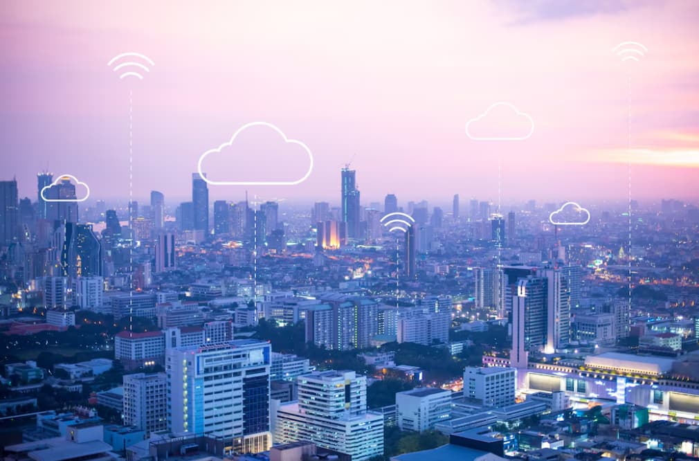 A cityscape with digital clouds and connectivity symbols